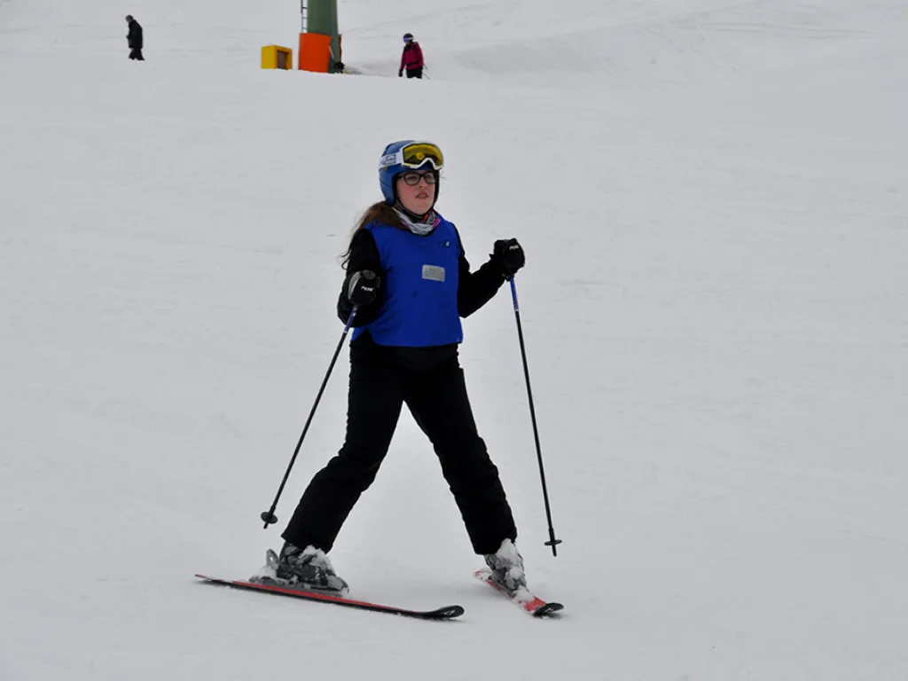 Skifahrerin steht mit Skibrille auf der Piste.